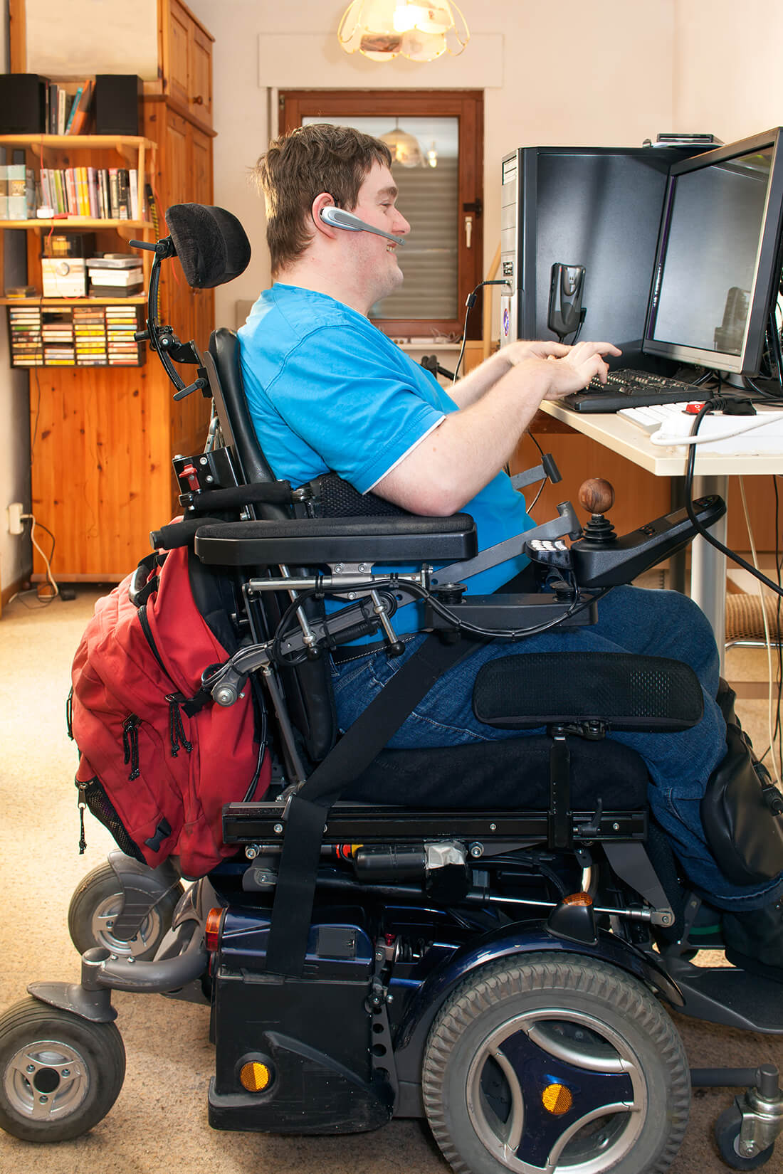 Gentleman with cerebral palsy in electric wheelchair user using a computer